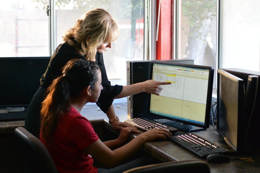 Girl at computer with mentor